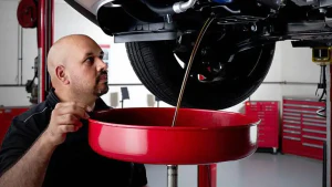 Kia tech draining vehicle in service centre