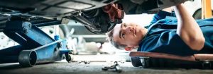 Kia tech working underneath vehicle