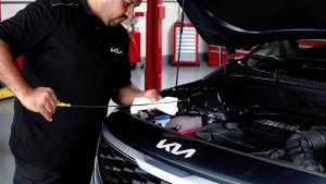 Technician looking at oil level on Kia