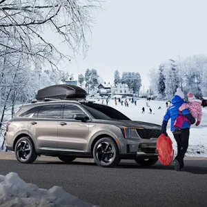 People walking by kia vehicle with snow in background